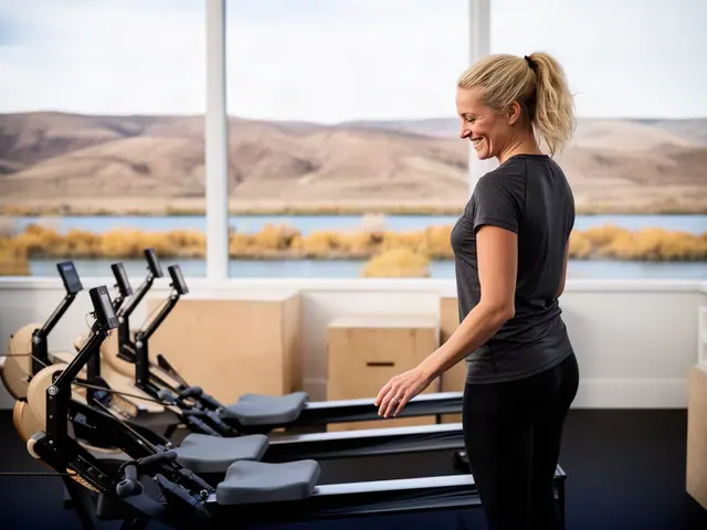 A woman with a high blonde ponytail beside new equipment in a small fitness studio.